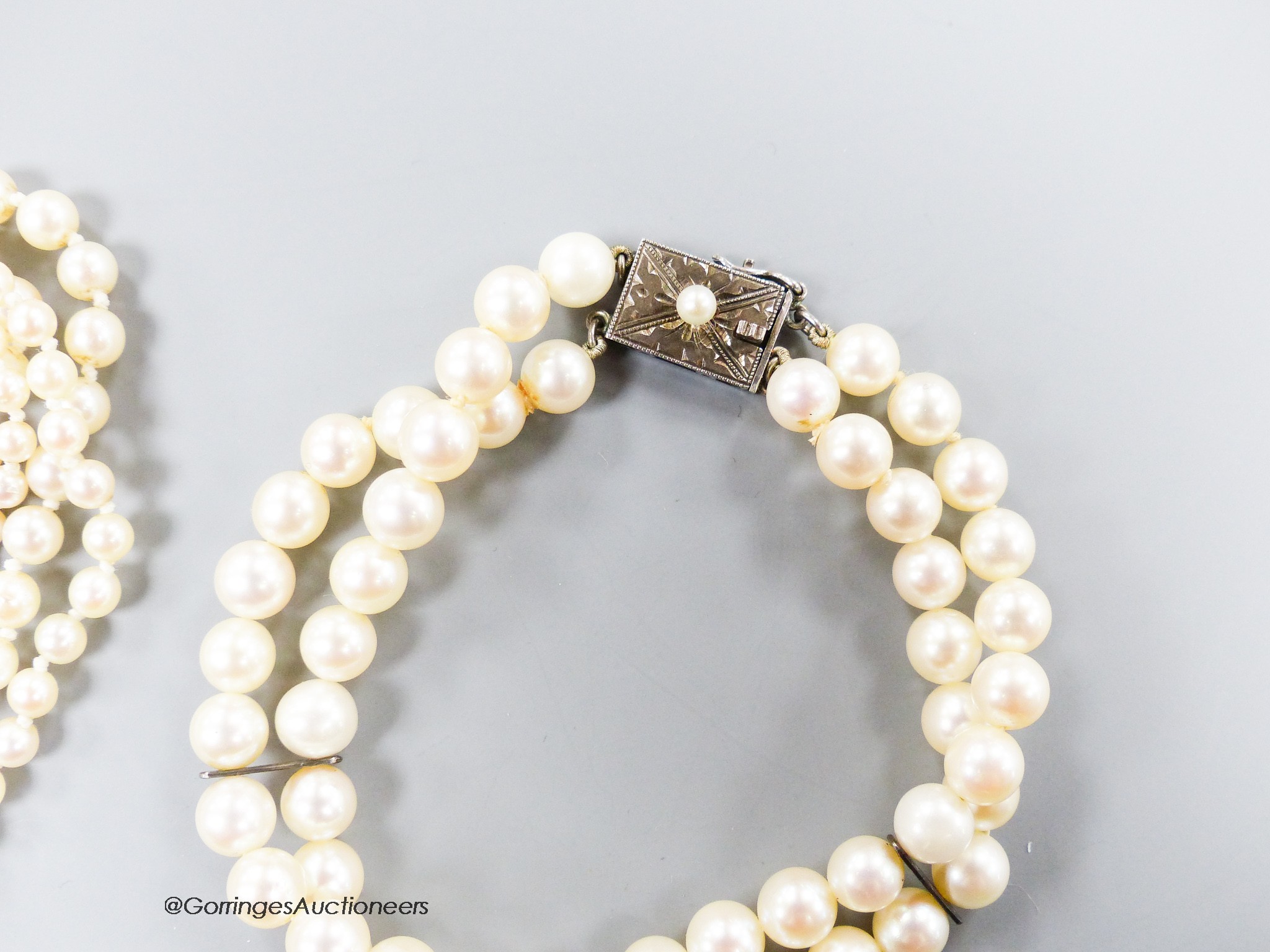 A long single strand graduated cultured pearl necklace, with marcasite clasp, 90cm, one other similar smaller necklace, a similar double strand bracelet and a pair of earrings(a.f.).